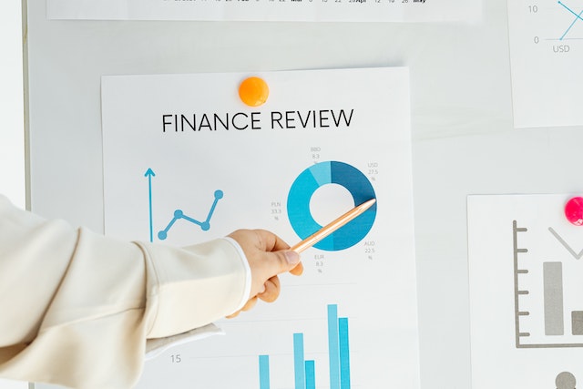 hand pointing to a document with a title saying financial review