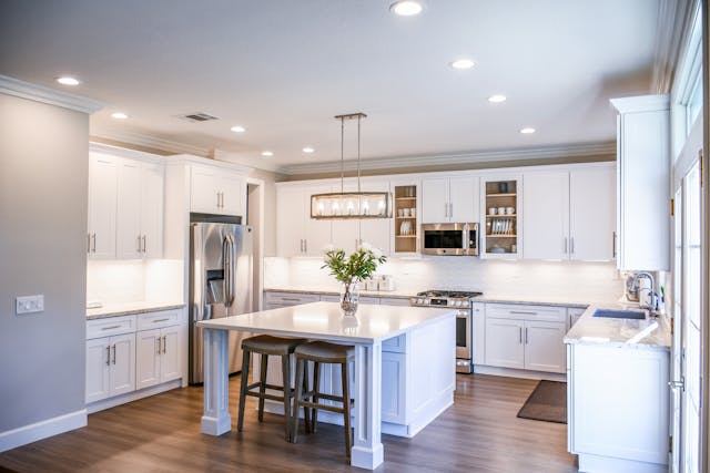 a kitchen with white counters and cabinets and a large central island