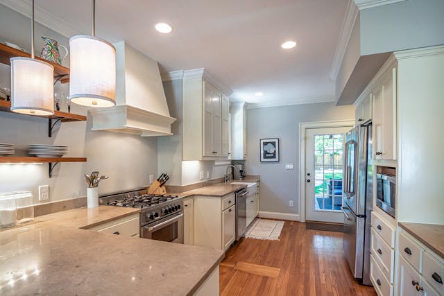 a light blue and white kitchen with modern appliances