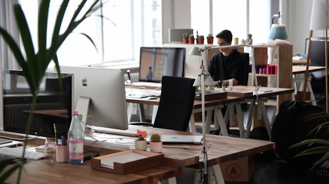 person sitting at their desk in a large communal office