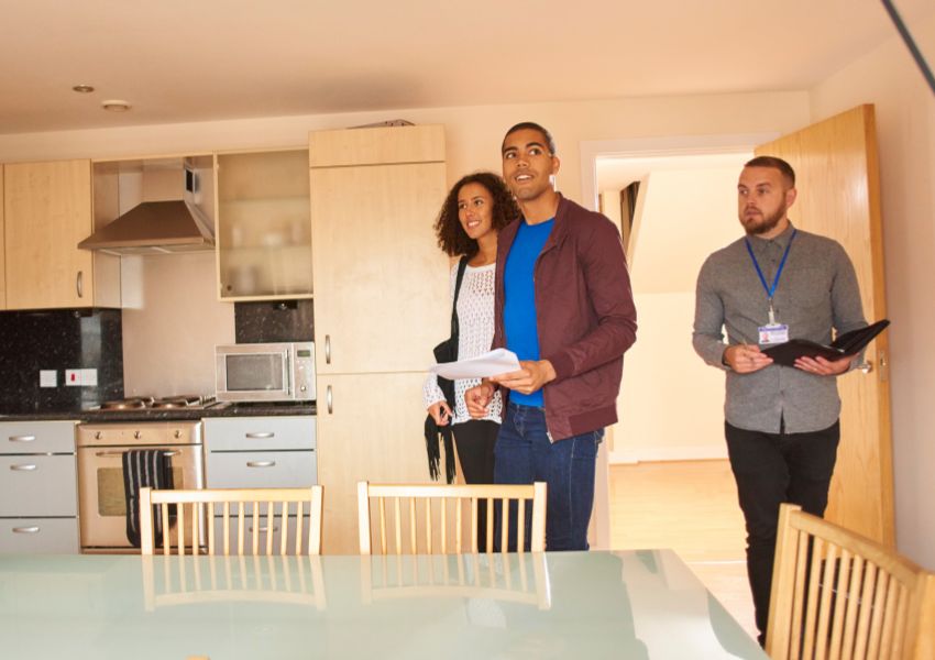 A couple of tenants taking a tour of a rental property with a property manager