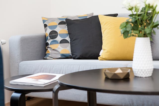 a couch with yellow and blue throw pillows