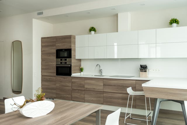 a modern kitchen with white and light wood cabinets