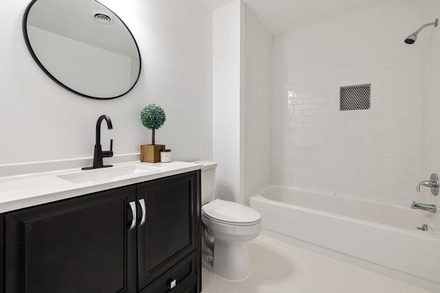 a small white bathroom with a dark wood vanity